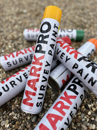Several MarkPro Survey Paint cans on gravel, caps showing the colour range